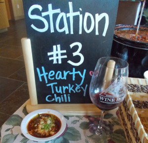 Sign for Station #3 hearty turkey chili with Wine Road glass and a sample of chili