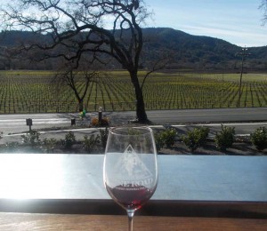 Wine Road glass with a vineyard view in the background