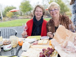 Two woman enjoying a picnic lunch.