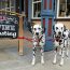 Two Dalmatians tied to a sign that reads"Open today for Wine tasting"