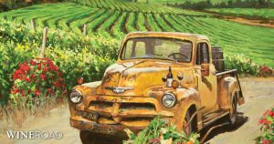 painting of an old chevy truck with barrels in the back on a vineyard lined road