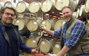 Benovia's winemaker and co-owner Mike Sullivan pouring wine from a barrel of Pinot Noir using a wine thief.