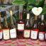 Bottles of Rose wine lined up on a bench with a white lily in the background