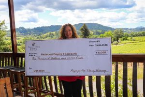 Renae Perry, co-owner of Papapietro Perry Winery, holds a $6000 check for the Redwood Empire Food Bank. A donation from wine sales.