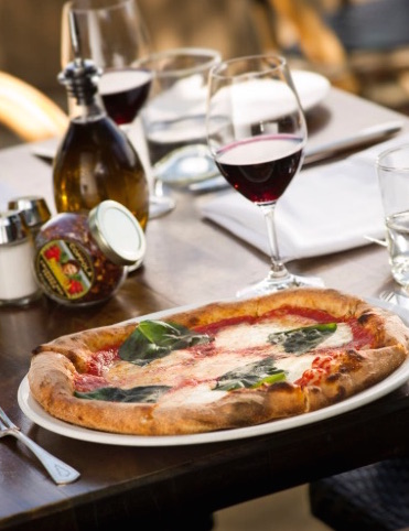 Pizza and a glass of red wine at Rustic restaurant