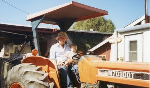 Leo Trentadue on a Kubota tractor with his tiny grandson Steve.